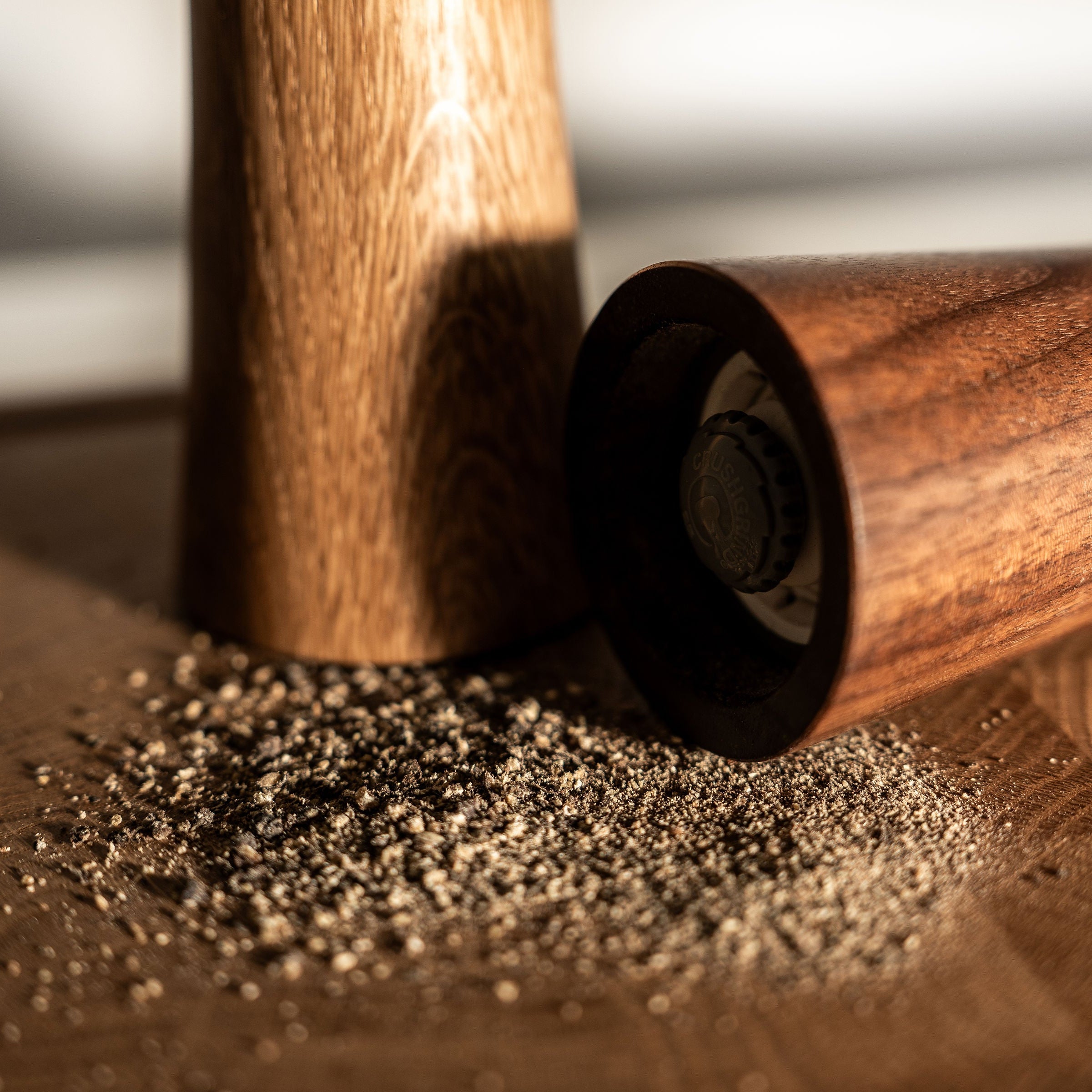 handgefertigte Salzmühle Pfeffermühle aus Eiche und Nussbaum mit frisch gemahlenem Pfeffer.